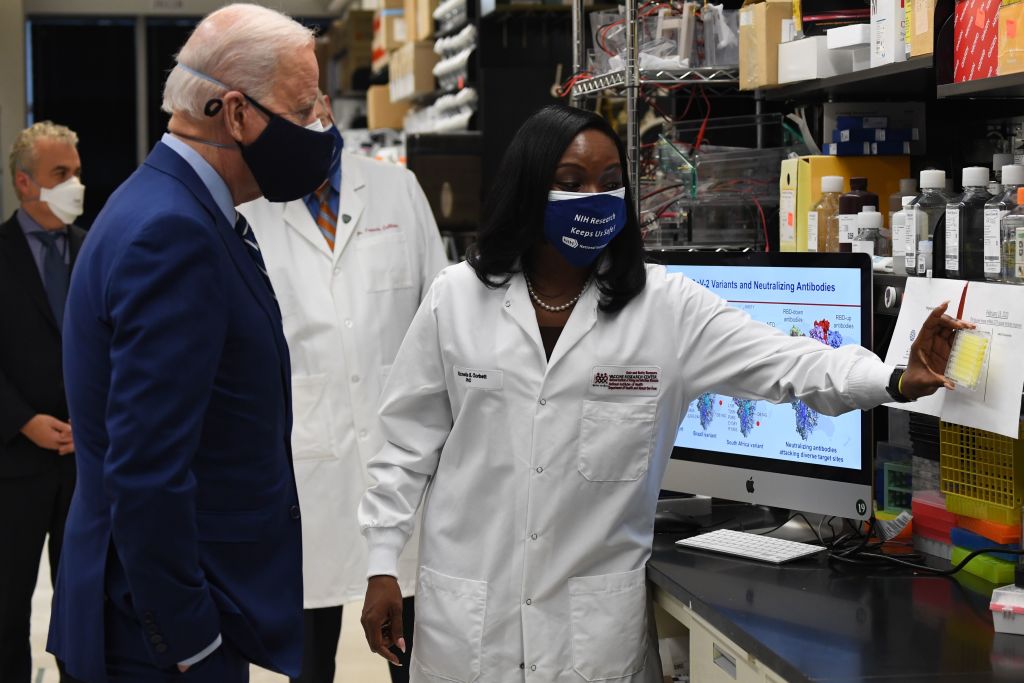 US President Joe Biden (L) listens to Dr. Kizzmekia S. Corbett (R)