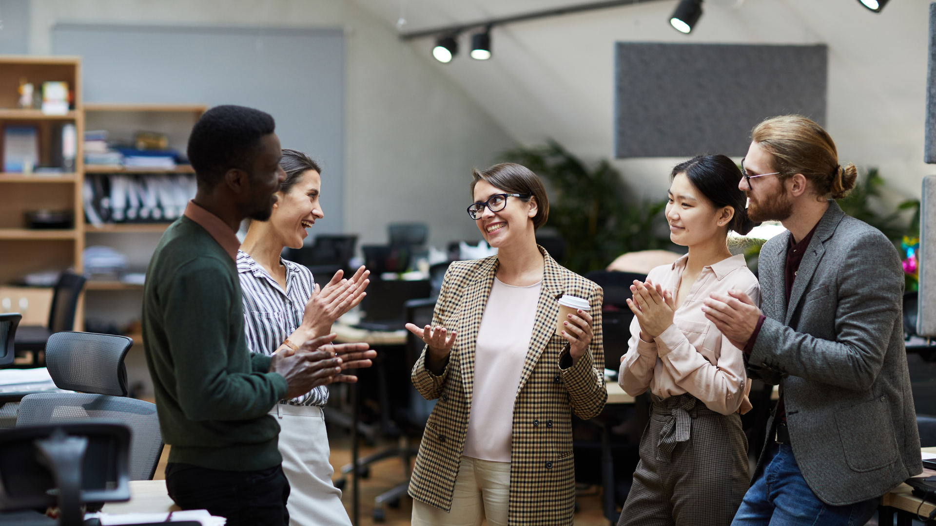 Group of coworkers congratulating worker