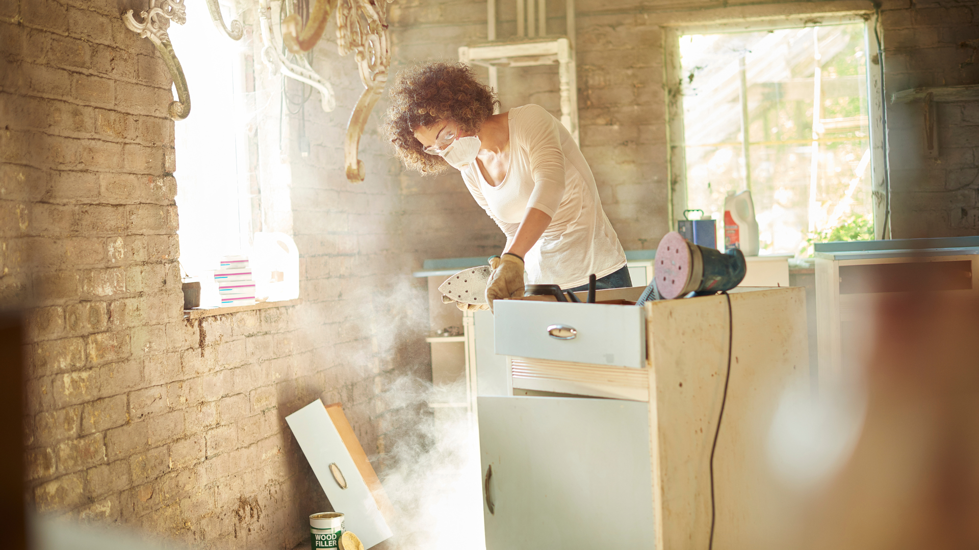 Woman sanding furniture for upcycling