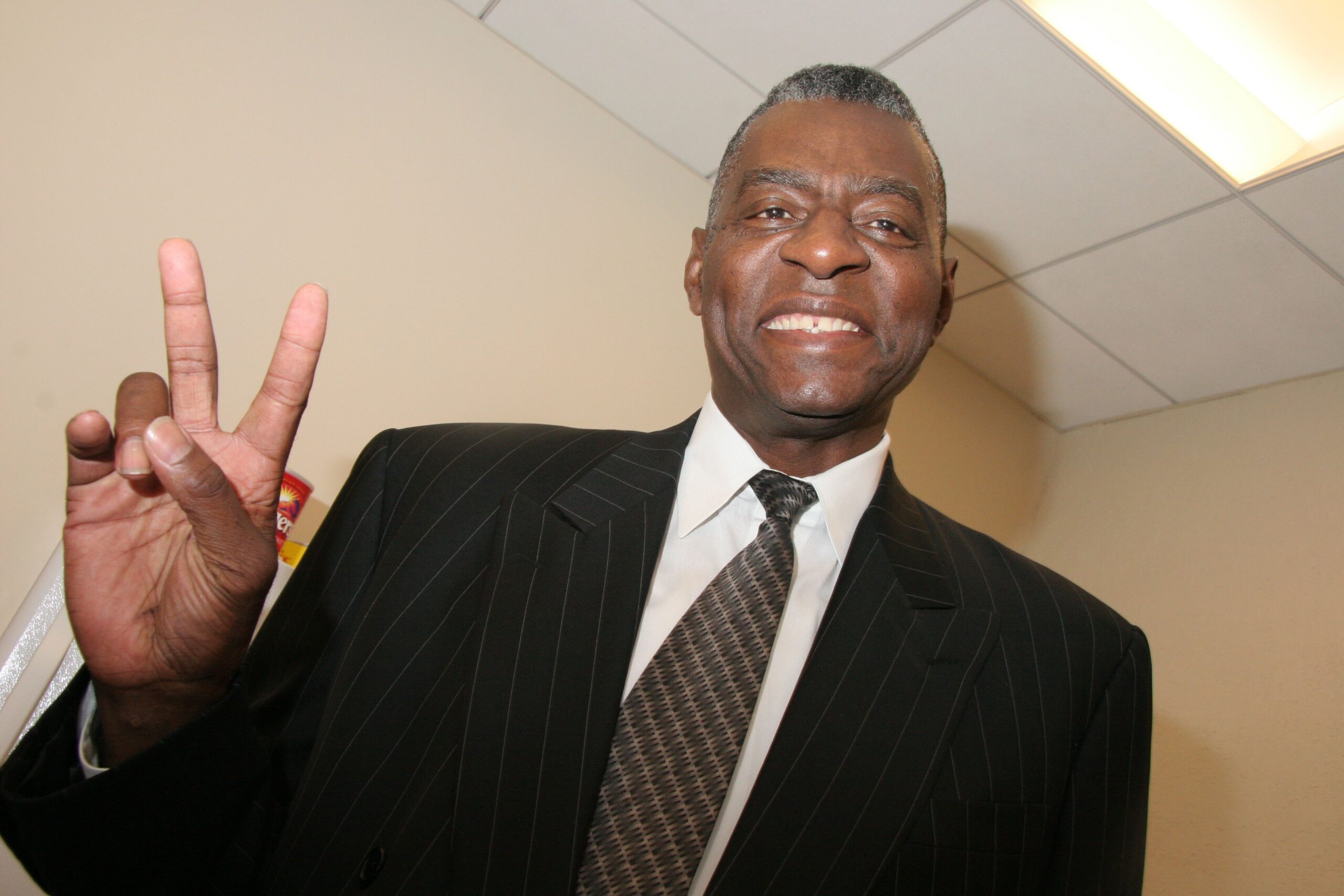 NBA Legend Bob Love posing with a peace sign and smiling